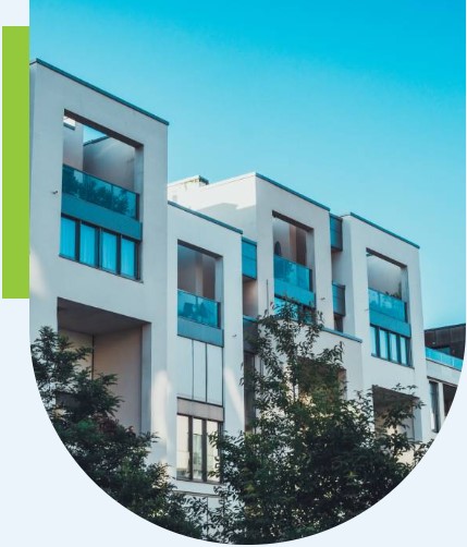 Modern apartment building financed with business loans, featuring reflective windows against a clear blue sky.