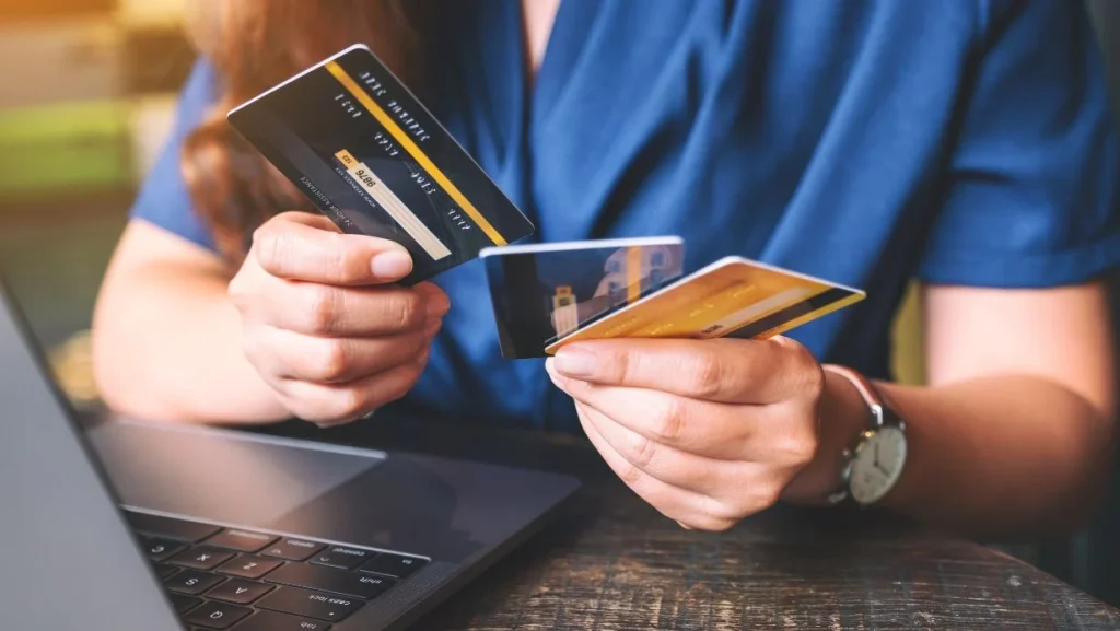 A Woman Holding And Choosing Credit Cards While Using Laptop Computer 1024x577