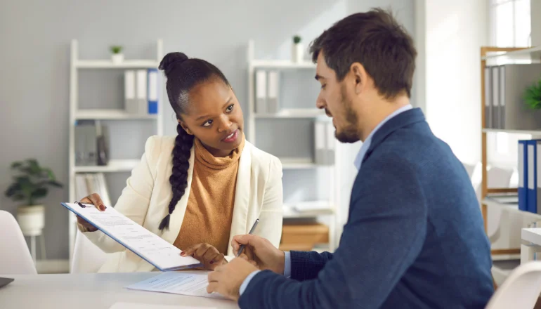 Afro American Solicitor Pointing At Insurance Contract Showing Client To Sign