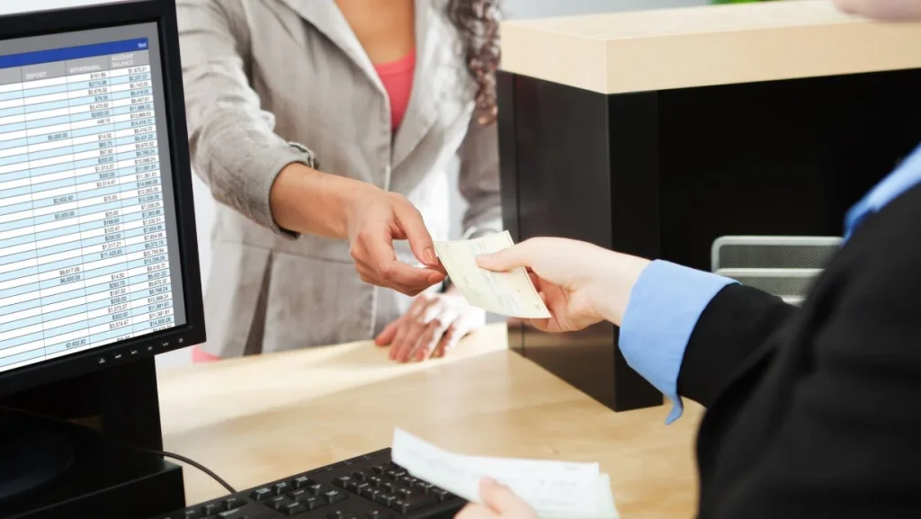 bank teller service with customer deposit transaction over business counter