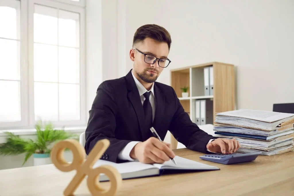 Business Accountant At Office Desk Calculating Corporate Tax And Interest Rate Percent 1024x683