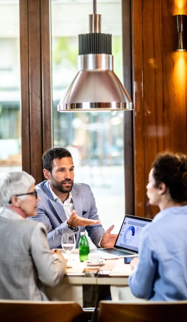 co-investors-analyzing-a-pie-chart-on-a-laptop-with-a-colleague