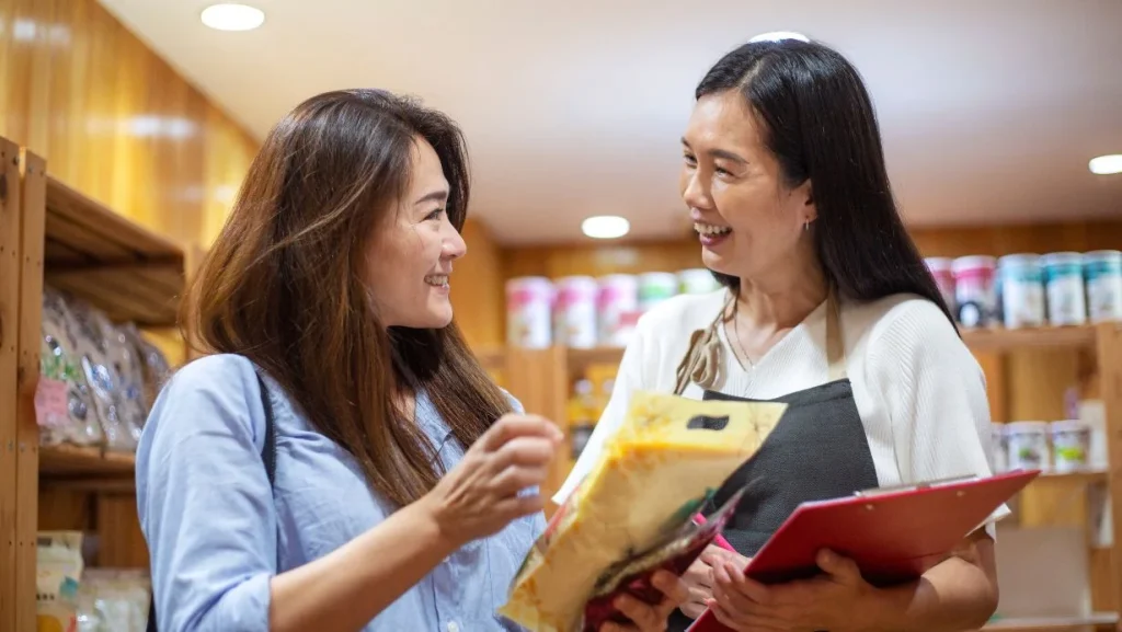 Female Store Worker Assisting Customer In A Retail Shop 1024x577