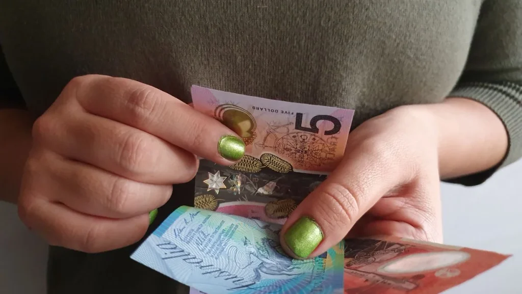 Hands Of A Woman Counting Australian Money 1024x577