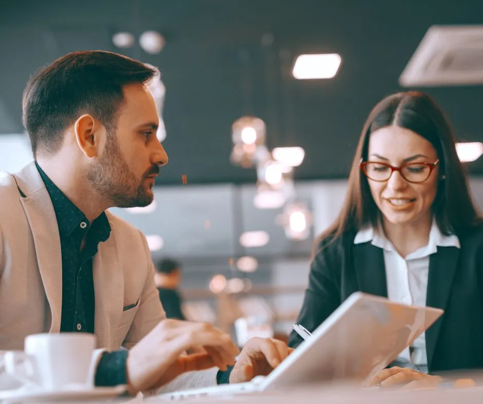 businessman-using-laptop-and-talking-to-his-female-colleague