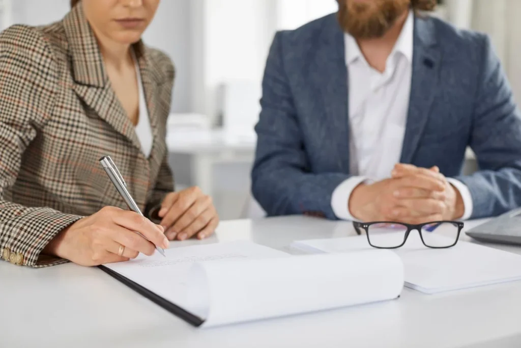 Woman In Office Signs Paper Document Confirming Purchase Of Loan From Bank 1024x683