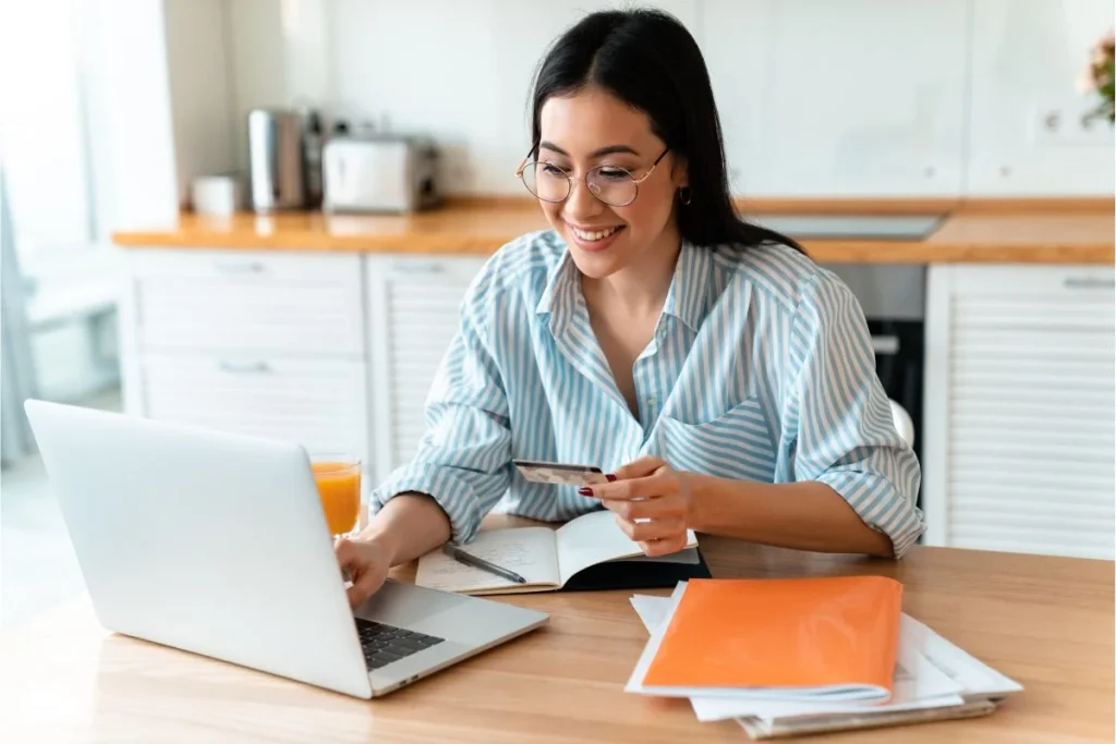 Woman Using Laptop While Holding Credit Card 1024x683