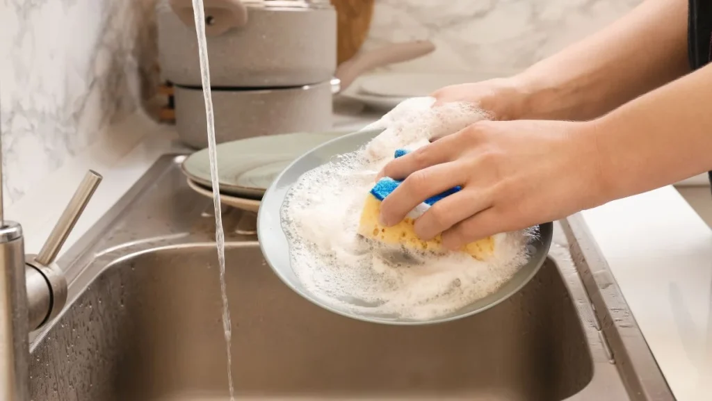 Woman Washing Dishes In Kitchen Sink 1024x577